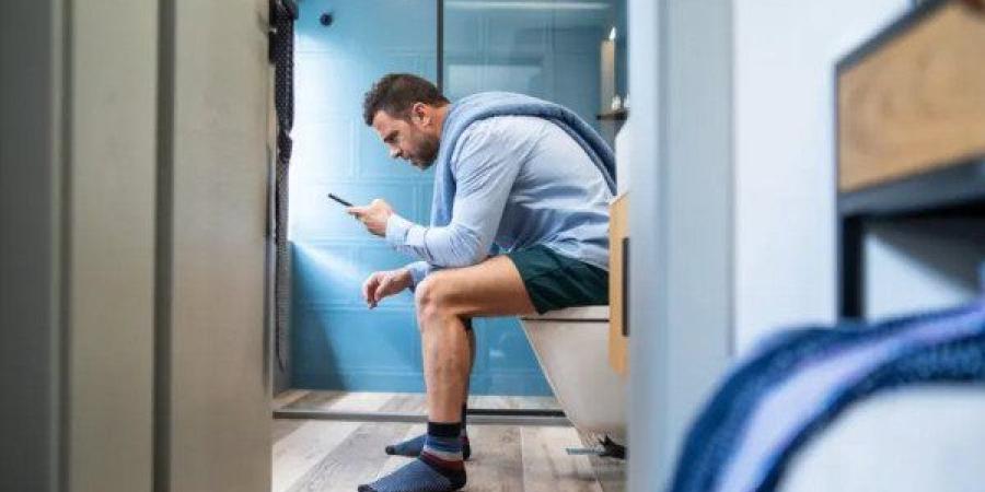 هل يؤدي الجلوس على الهاتف في المرحاض إلى البواسير؟.. دراسة تكشف الحقيقة